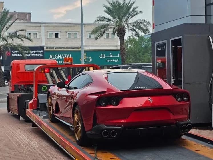 سطحة هيدروليك فل داون (نزول كامل) تنقل سيارة فيراري حمراء رياضية في شوارع جدة بكل أمان.