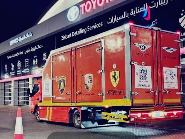 سطحَة مغلقة حمراء بشعارات السيارات الفاخرة، نقل آمن من سطحات البدر السريع إلى المنامة، البحرين.