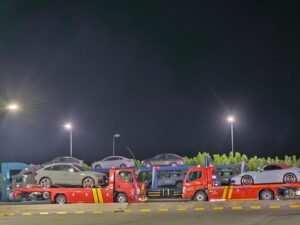ا نقل سيارات (سطحات حمراء) تنقلان عدة سيارات ليلاً، لخدمات نقل السيارات بين المعارض في جدة من سطحات البدر السريع.
